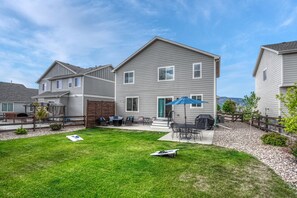 Un immeuble résidentiel de deux étages doté d’un patio aménagé avec des meubles d’extérieur et un barbecue.