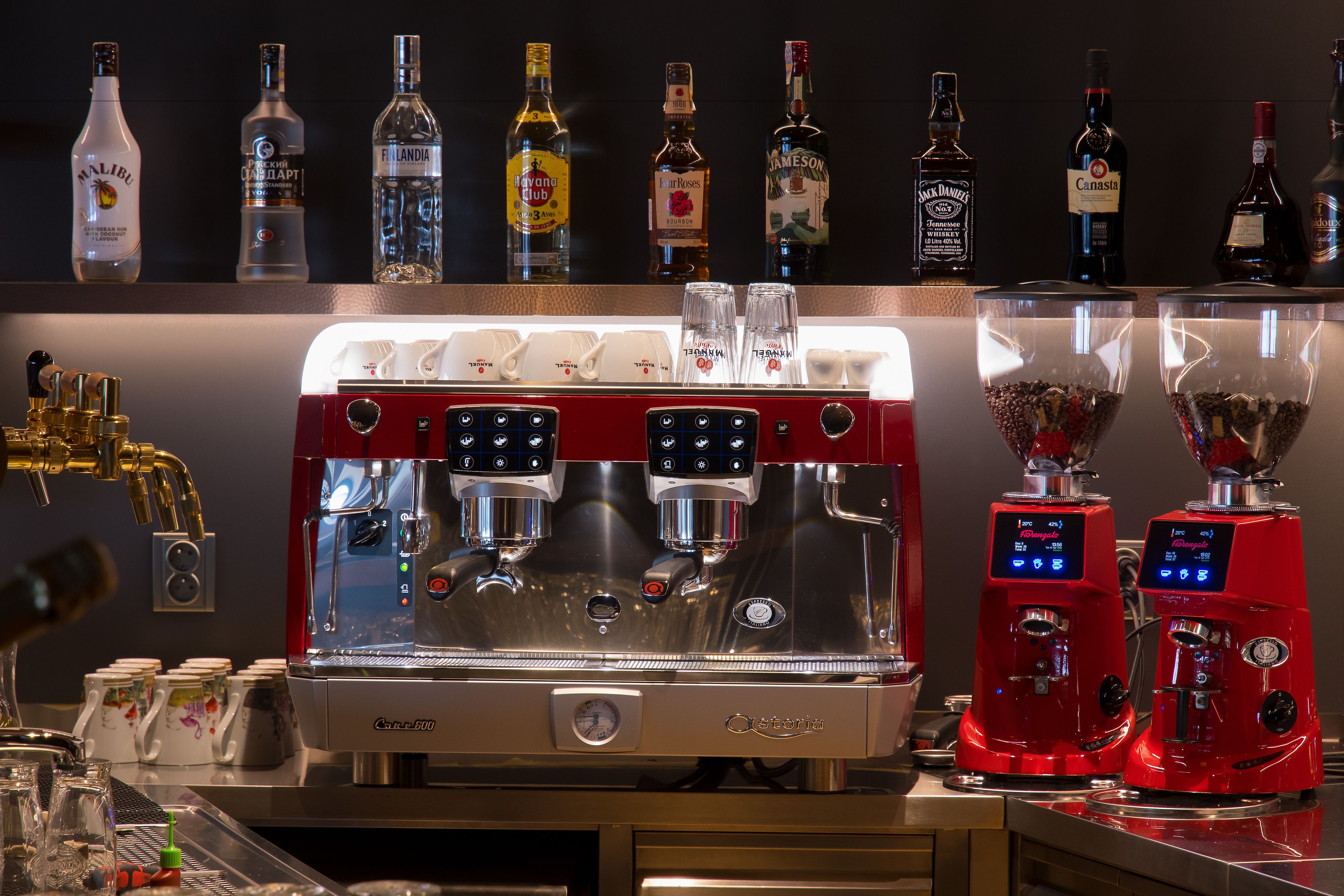 A bar area with a coffee machine, a selection of liquor bottles, and a coffee grinder.