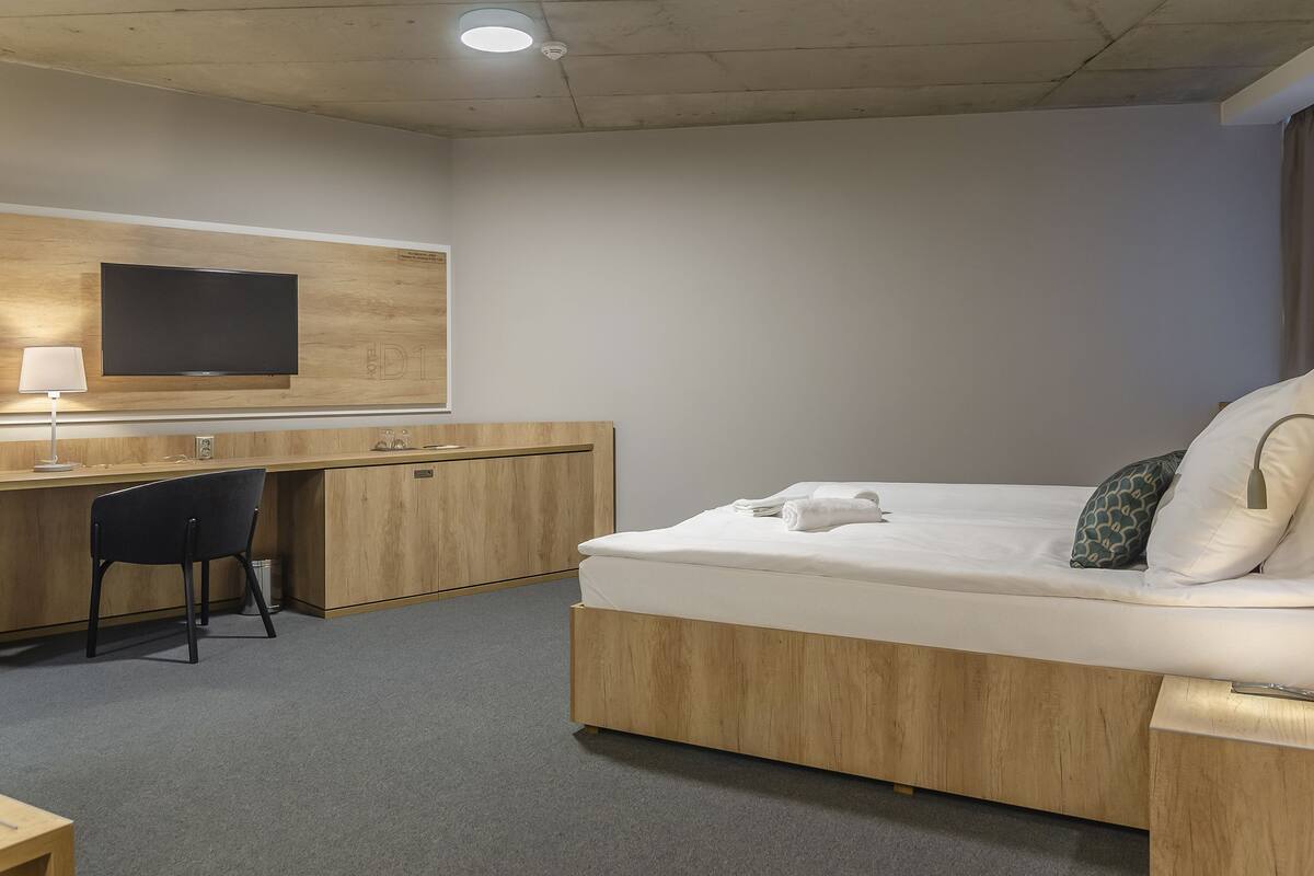 Une chambre d’hôtel avec un lit, un bureau et une télévision.