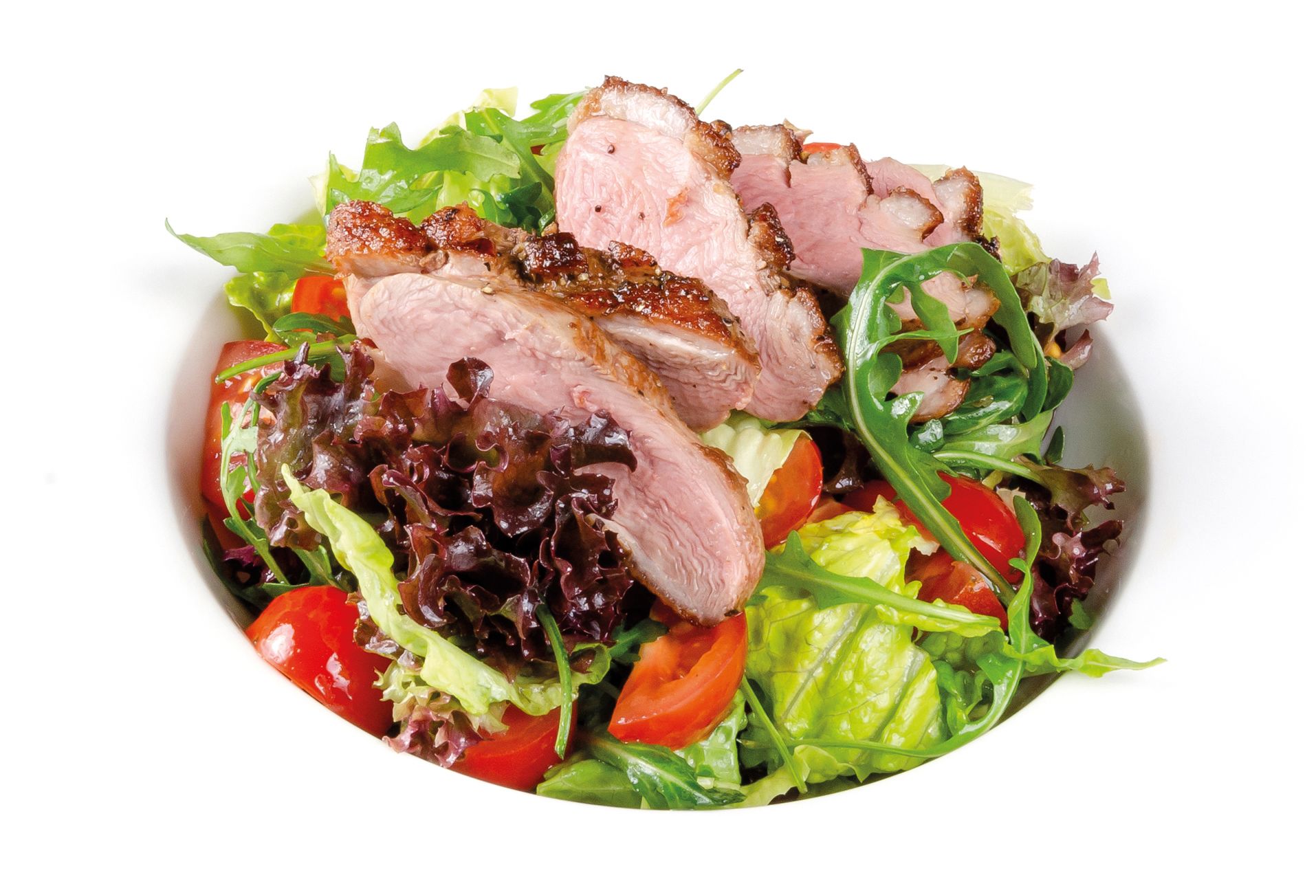 Een salade met verschillende bladgroenten, tomaten en plakjes vlees.