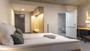 A hotel room with a bed, a desk, a chair, a bathroom, and a wardrobe. - Hotel D1 (Ostrovacice)