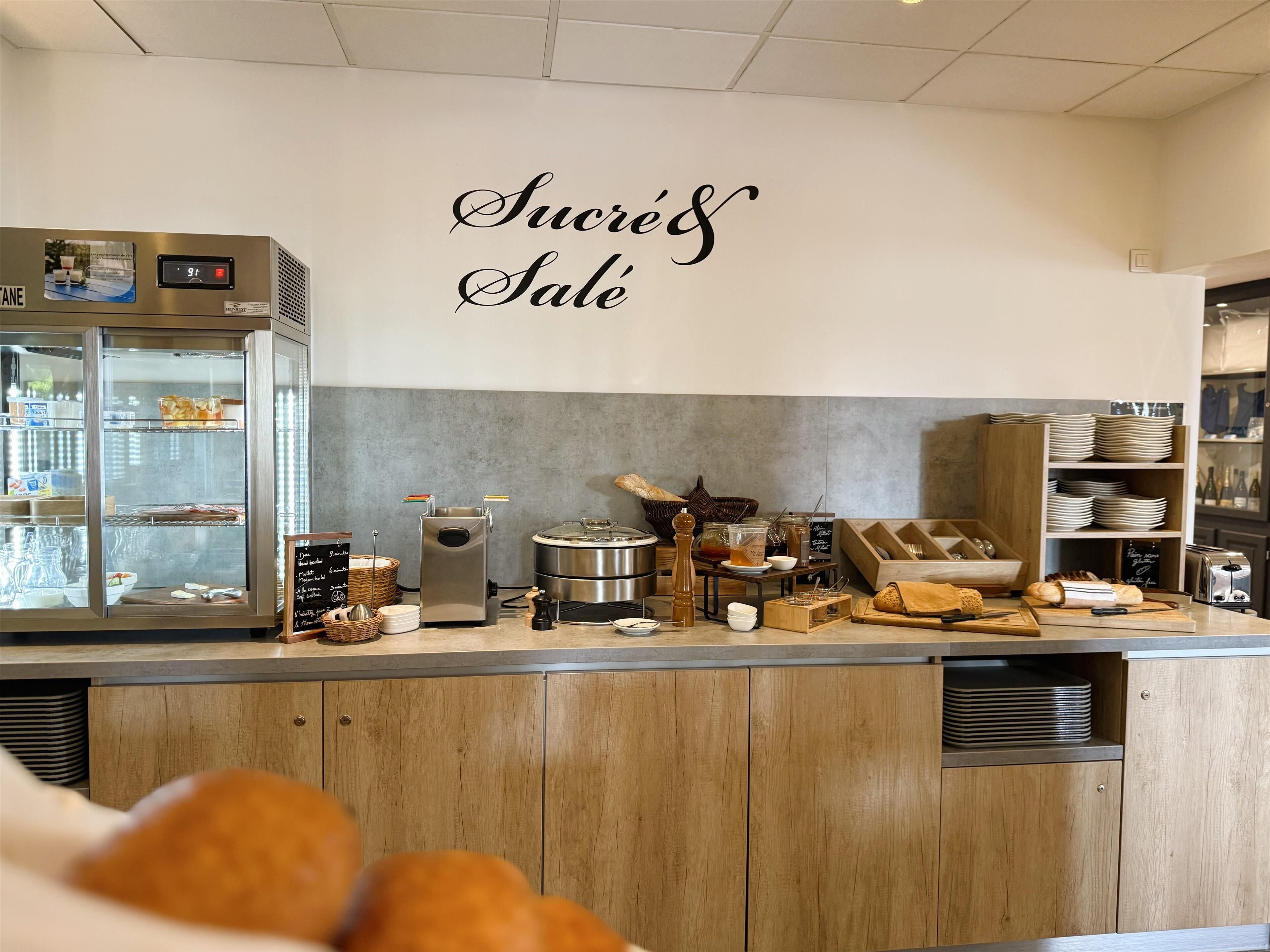 A bakery counter with a display case, a coffee machine, and various baking tools.