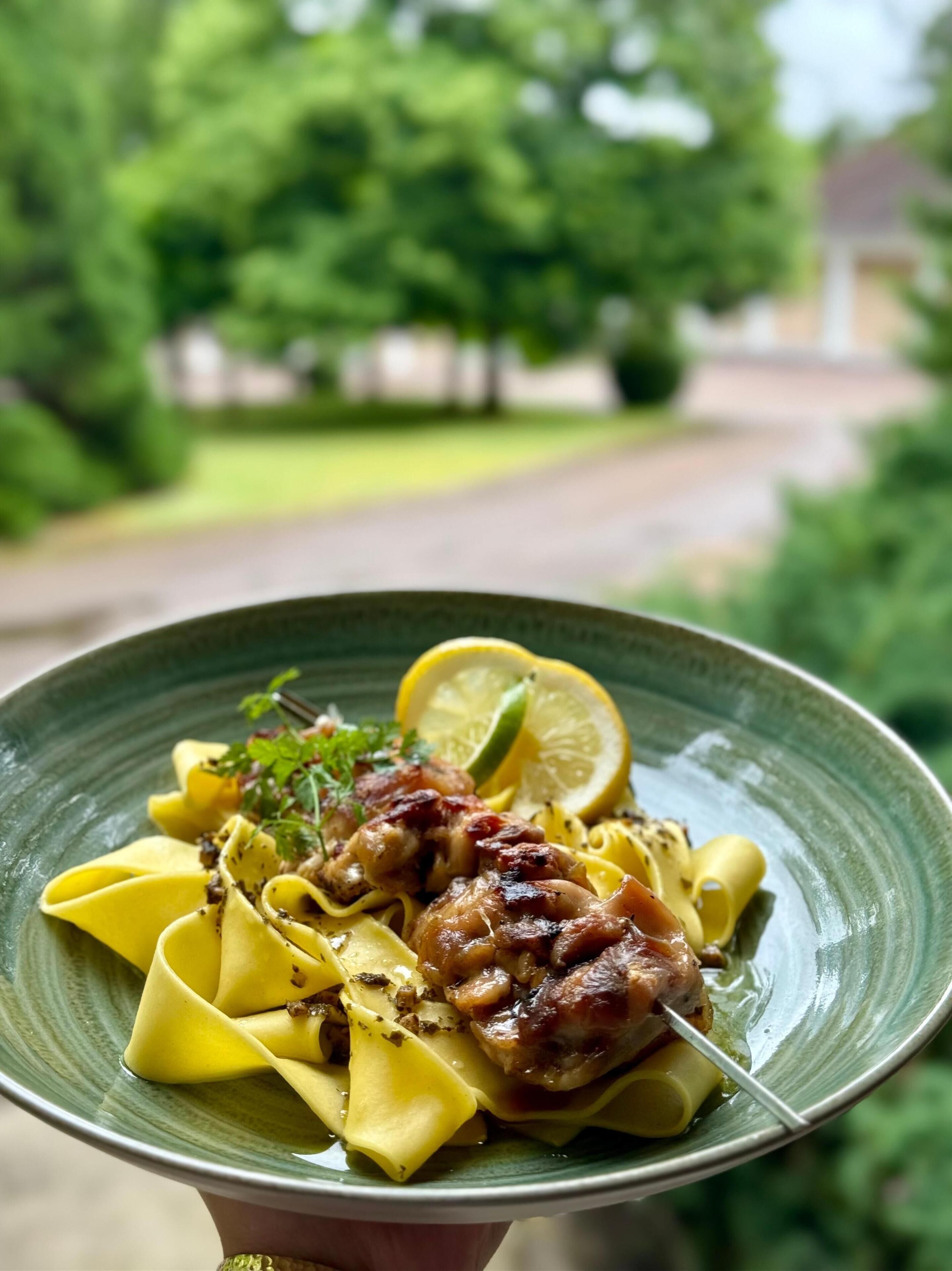 Un plato de pasta con rodajas de limón y hierbas.