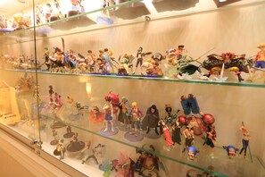 A display case with various figurines arranged on shelves. - Doll House Lodge (Hengchun)