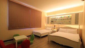Una habitación de hotel con dos camas, una mesita, una silla verde y una silla roja.