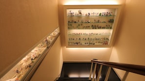 Una escalera con una exhibición de figuritas en la pared.