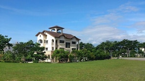 A multi-story building with a central tower, surrounded by a grassy area and trees. - Mallorca B&B (Taitung)