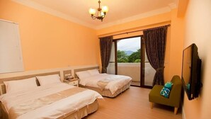 A hotel room with two beds, a small sofa, a TV, and a balcony with curtains. - Mallorca B&B (Taitung)