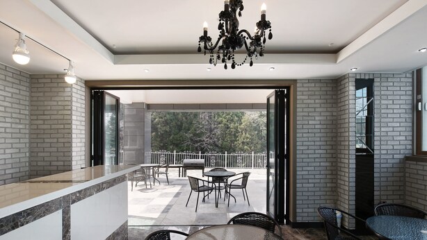 Un interior moderno con una zona de bar, asientos y vistas a través de un ventanal.