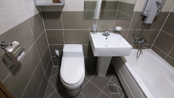 A bathroom with a toilet, sink, and bathtub.
