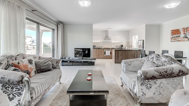 Una sala de estar moderna con un sofá, una mesa de centro y un televisor.