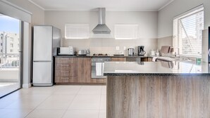 Una cocina moderna con una isla grande, electrodomésticos integrados y vistas a la ciudad.