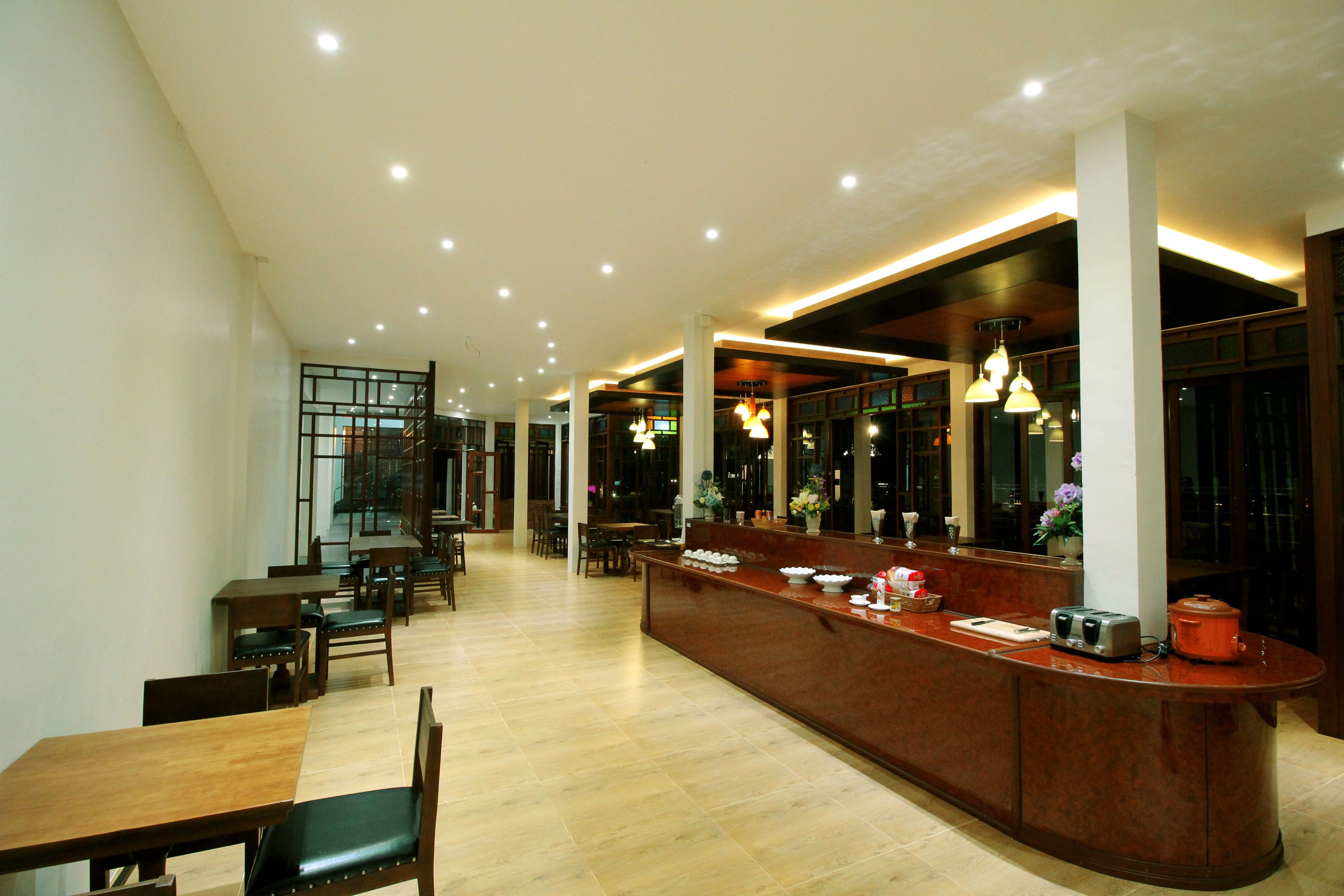 A spacious restaurant with a long counter, multiple seating areas, and a modern interior design.