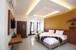 A modern hotel room with a large bed, a TV mounted on the wall, a wooden desk, and a ceiling with recessed lighting.