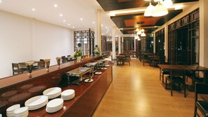 Montaje tipo buffet con varias estaciones de servicio, una larga barra con platos apilados y diversas opciones de asientos.