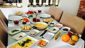 Una tavola imbandita con diversi piatti, tra cui uova, verdure e frutta, che suggerisce un'atmosfera da colazione o brunch.
