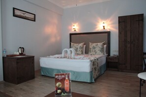 A hotel room with a bed, bedside table, wardrobe, and a framed picture on the wall. - Beyaz Konak Hotel (Sile)