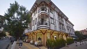 Un edificio ad angolo con diversi balconi, posti a sedere all'aperto e un cartello che indica che si tratta di un OTEL.