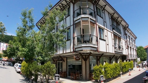 Un edificio d'angolo con un balcone, un cartello con la scritta 