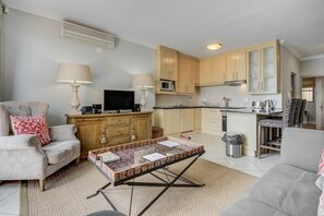 Departamento Deluxe, 1 habitación | Área de sala de estar | Televisión
