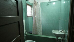Ein kleines Badezimmer mit Toilette, Waschbecken und Duschbereich.