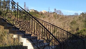 A stone staircase with ornate black metal railings leading up to a hilltop. - White Guest House (Batumi)
