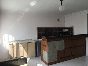 A kitchen with a wooden counter, a refrigerator, and cabinets. - White Guest House (Batumi)