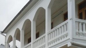 A two-story building with a white facade and a balcony on the upper floor. - White Guest House (Batumi)