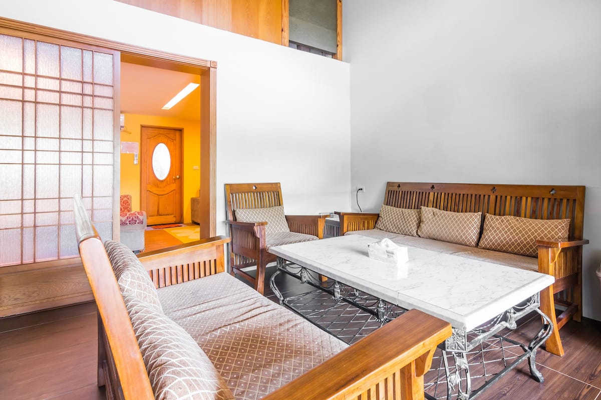 A traditional Japanese-style room with tatami flooring, a low table, and wooden furniture.