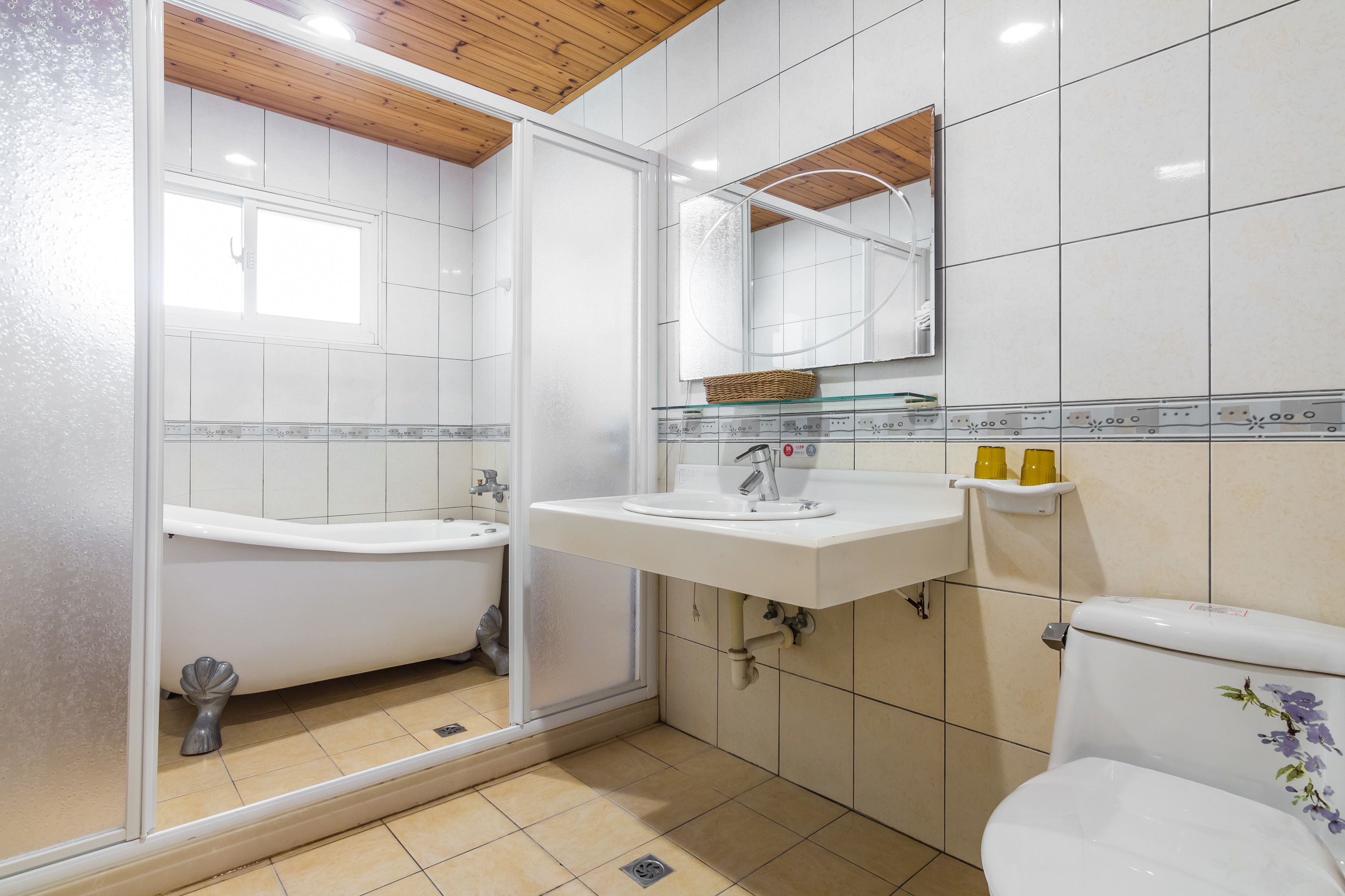 A bathroom with a bathtub, a sink, a toilet, and a mirror.