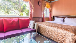 A room with a bed, a sofa, and a glass table. - Kenting Maya House B&B (Hengchun)