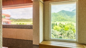 A room with a large window overlooking a green landscape and hills. - Kenting Maya House B&B (Hengchun)