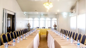 A conference room with a long table, chairs, and water bottles. - The Father's Hotel (Accra)