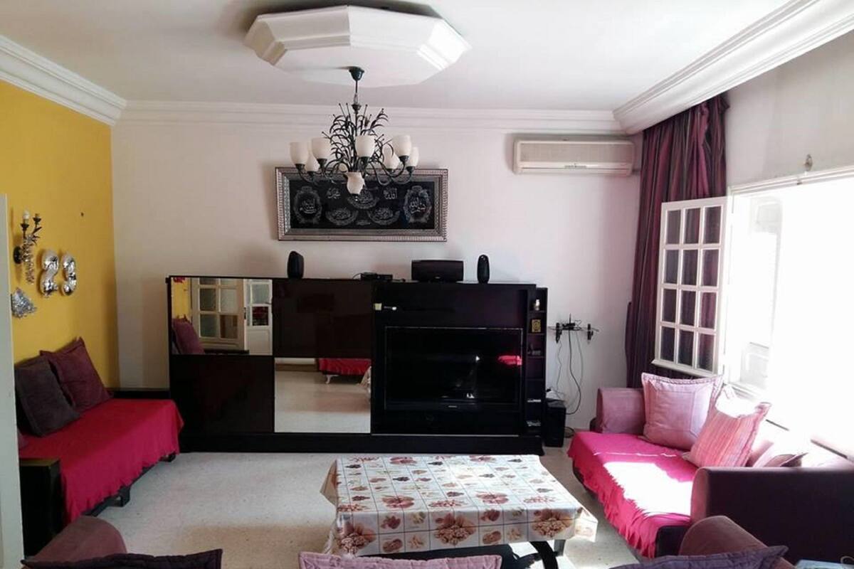 A living room with a sofa set, a coffee table, a fireplace, and a large mirror.
