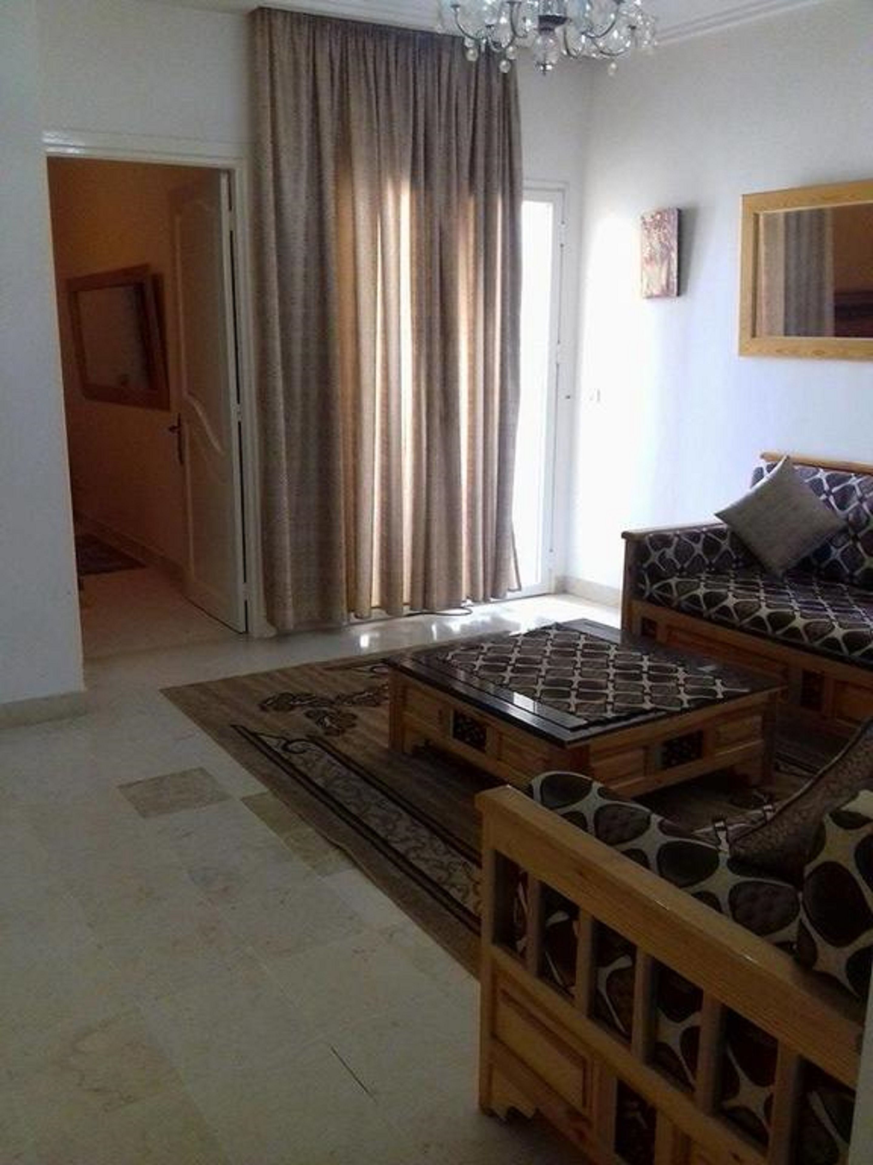 A living room with a sofa, a coffee table, and a patterned rug.