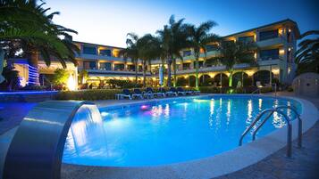 Een buitenzwembad, parasols voor strand/zwembad