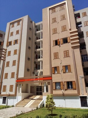 A multi-story residential building with a central staircase, balconies, and a flat roof. - Benzineb Immo Menzeh (Ariana)