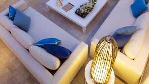 A modern outdoor living area with a white sofa set, a dining table with chairs, and a decorative lamp. - Dar Indigo (Sidi Bou Said)