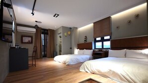 Une chambre d’hôtel avec deux lits, un bureau et une vue sur l’extérieur.