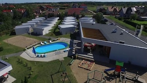 Zona residencial con piscina, un espacio exterior cubierto y varias casas independientes.