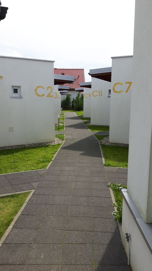 Un camino que lleva a un edificio con secciones numeradas C2, C3, C7 y C8.