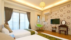Une chambre d’hôtel avec deux lits, un fauteuil suspendu, une télévision et une petite table.