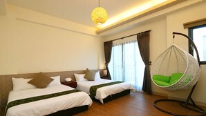 Une chambre d’hôtel avec deux lits, un fauteuil suspendu et une grande fenêtre avec des rideaux.