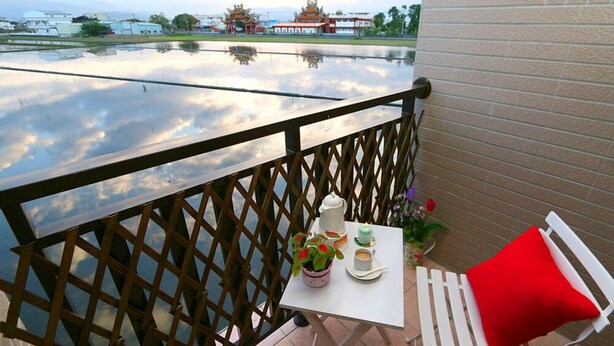 Un balcon avec une table, une chaise et une balustrade.