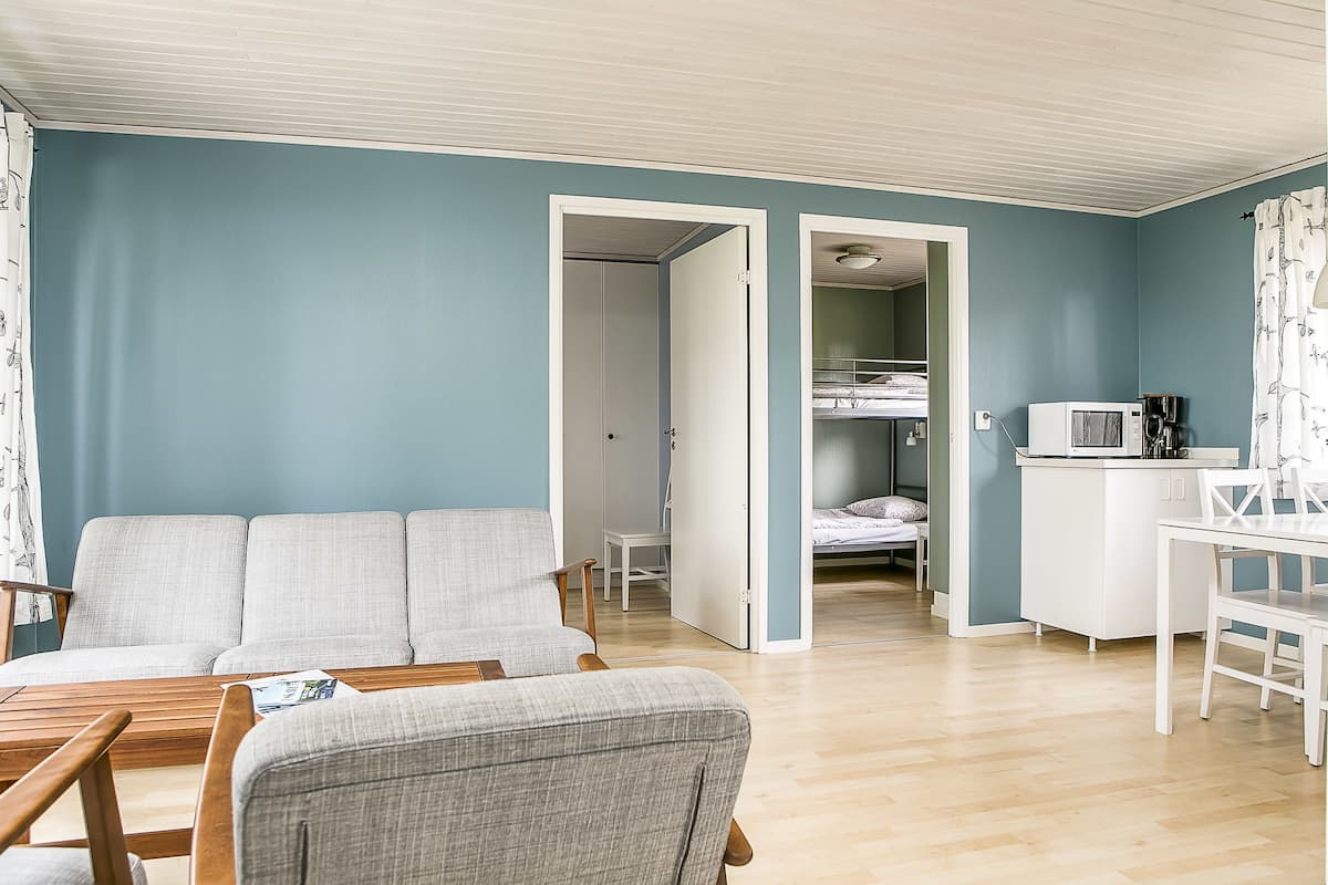 Una habitación con sofá, mesa de comedor y kitchenette.