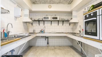 Habitación cuádruple básica, baño compartido | Cocina compartida | Refrigerador, microondas y artículos de limpieza