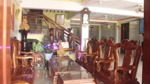 A spacious living room with a high ceiling, wooden furniture, and a staircase leading to an upper level. - Phong Nha River View Hotel (Phong Nha)
