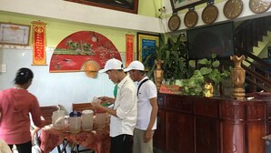 A reception area with a reception desk, a clock, and a painting on the wall. - Phong Nha River View Hotel (Phong Nha)