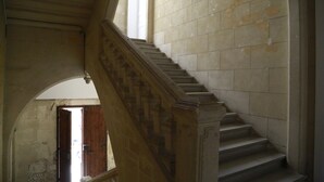 A grand staircase with ornate balustrades leading to an upper floor. - Palais de Luppé (Arles)