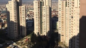 Un complejo residencial de edificios altos con varios edificios de apartamentos, un área de estacionamiento y vistas de la ciudad circundante.